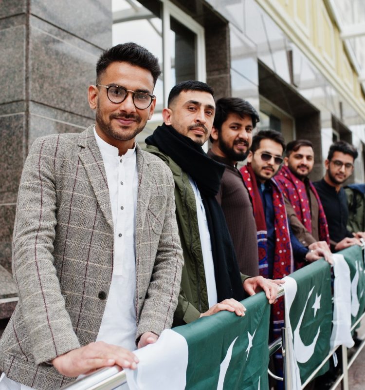 Group of pakistani man wearing traditional clothes salwar kameez or kurta with Pakistan flags.