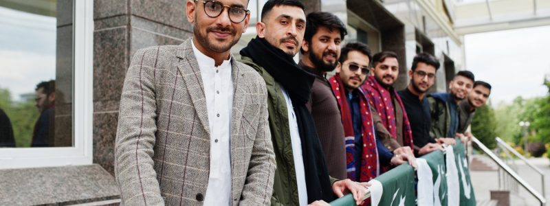 Group of pakistani man wearing traditional clothes salwar kameez or kurta with Pakistan flags.